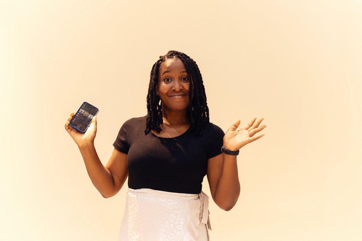 Entrepreneuse tenant son téléphone, souriante